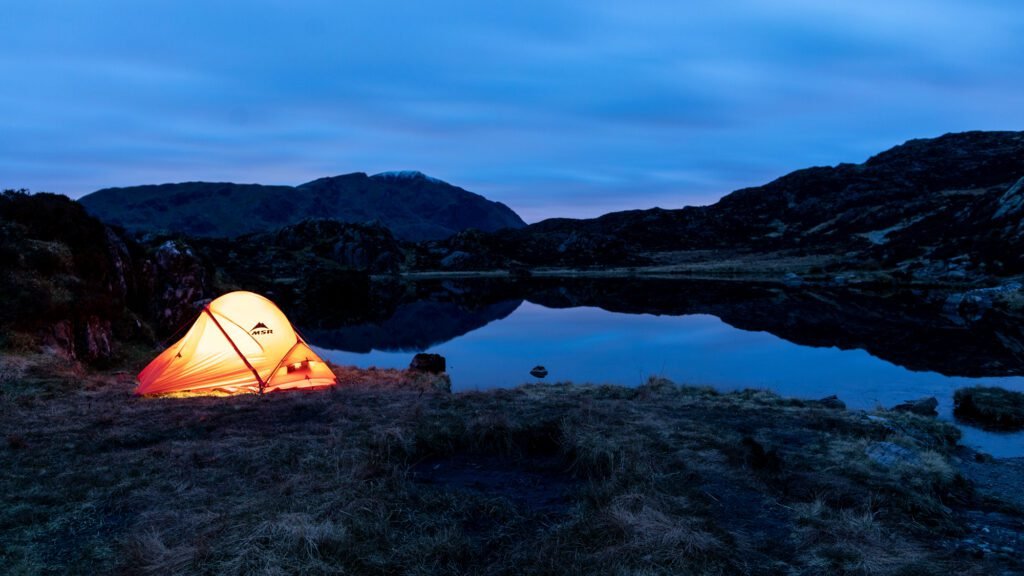 Innominate Tarn wild camp: the MSR Access 2 glowing at dusk beside the tarn on Haystacks