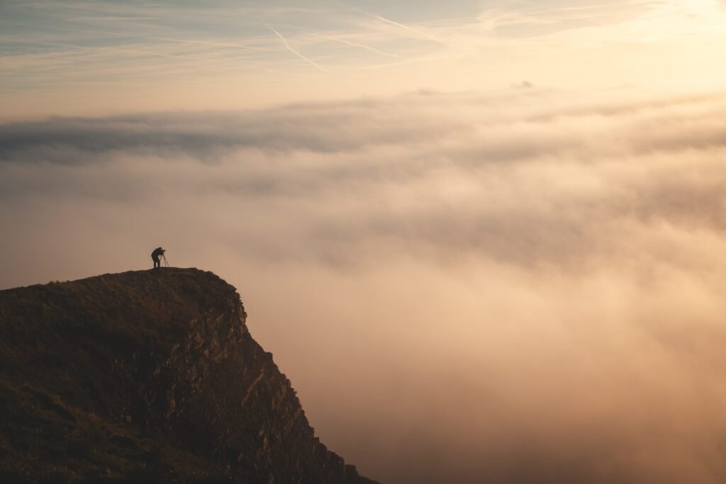 Photographer on the edge of Mam Tor above a cloud inversion