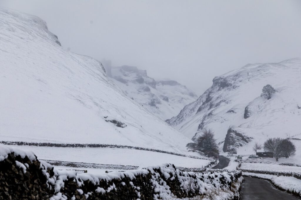 Winnats Pass in deep snow with the road winding down the gorge