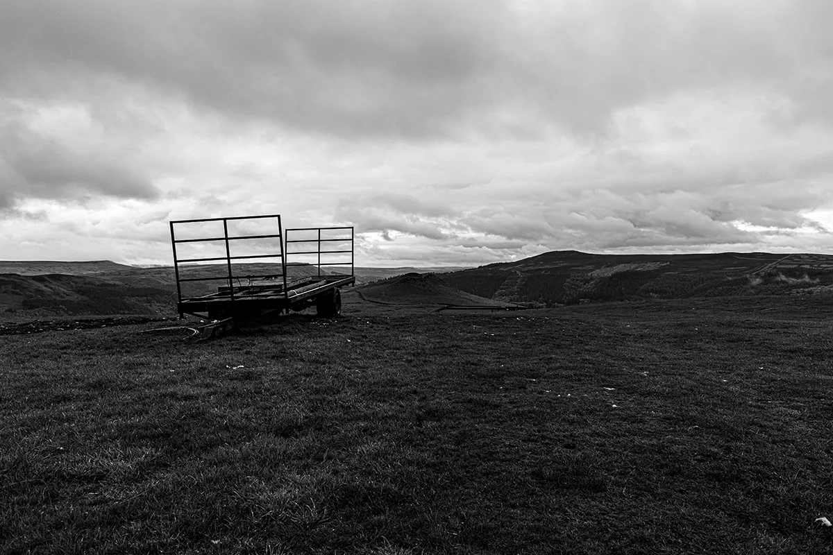 Old farm cart on Crook Hill with moody clouds over the Peak District