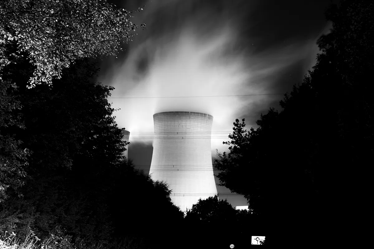 Drax cooling tower and steam at night from the roadside, black and white