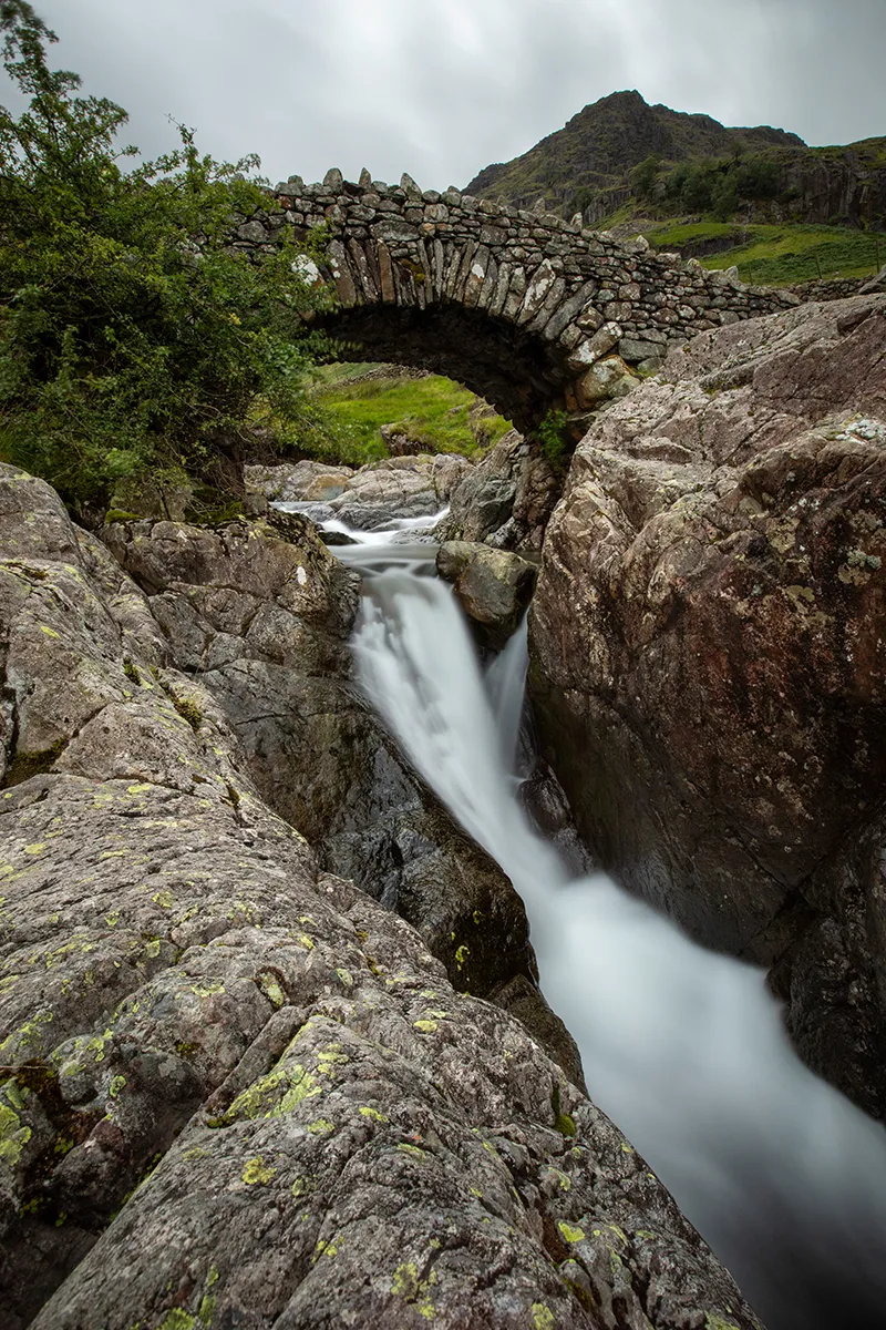 Colour long exposure of Stockley Bridge and the river in Borrowdale